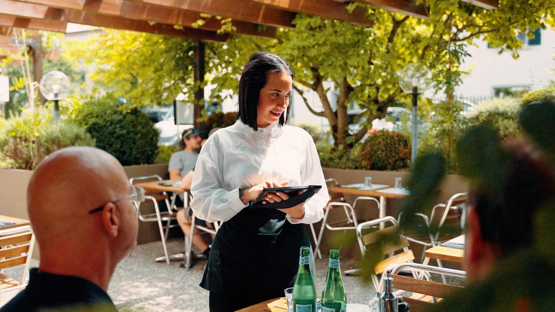 Kellnerin nimmt Bestellung direkt am Tisch mit dem iPad auf. Kassensystem Lightspeed von Vendomat.