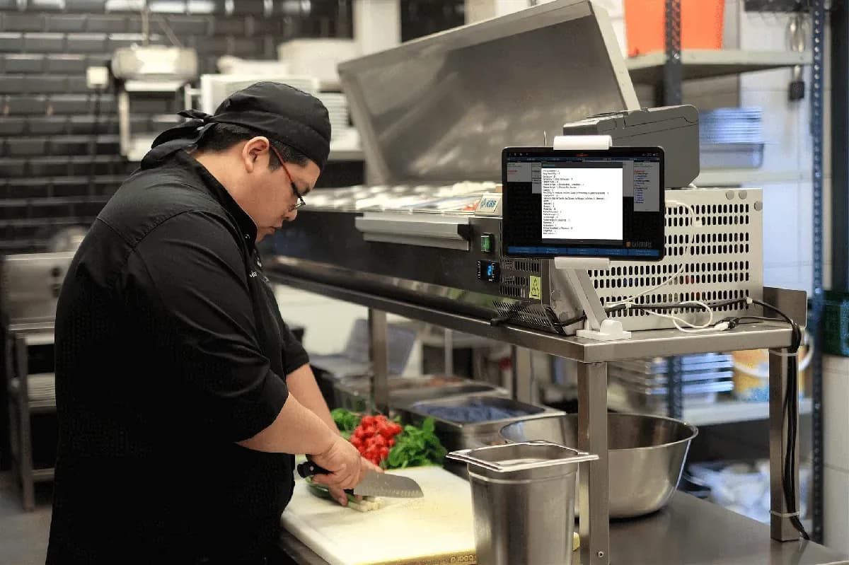 Koch nutzt Küchenmonitor von Vendomat zur Produktion von Speisen